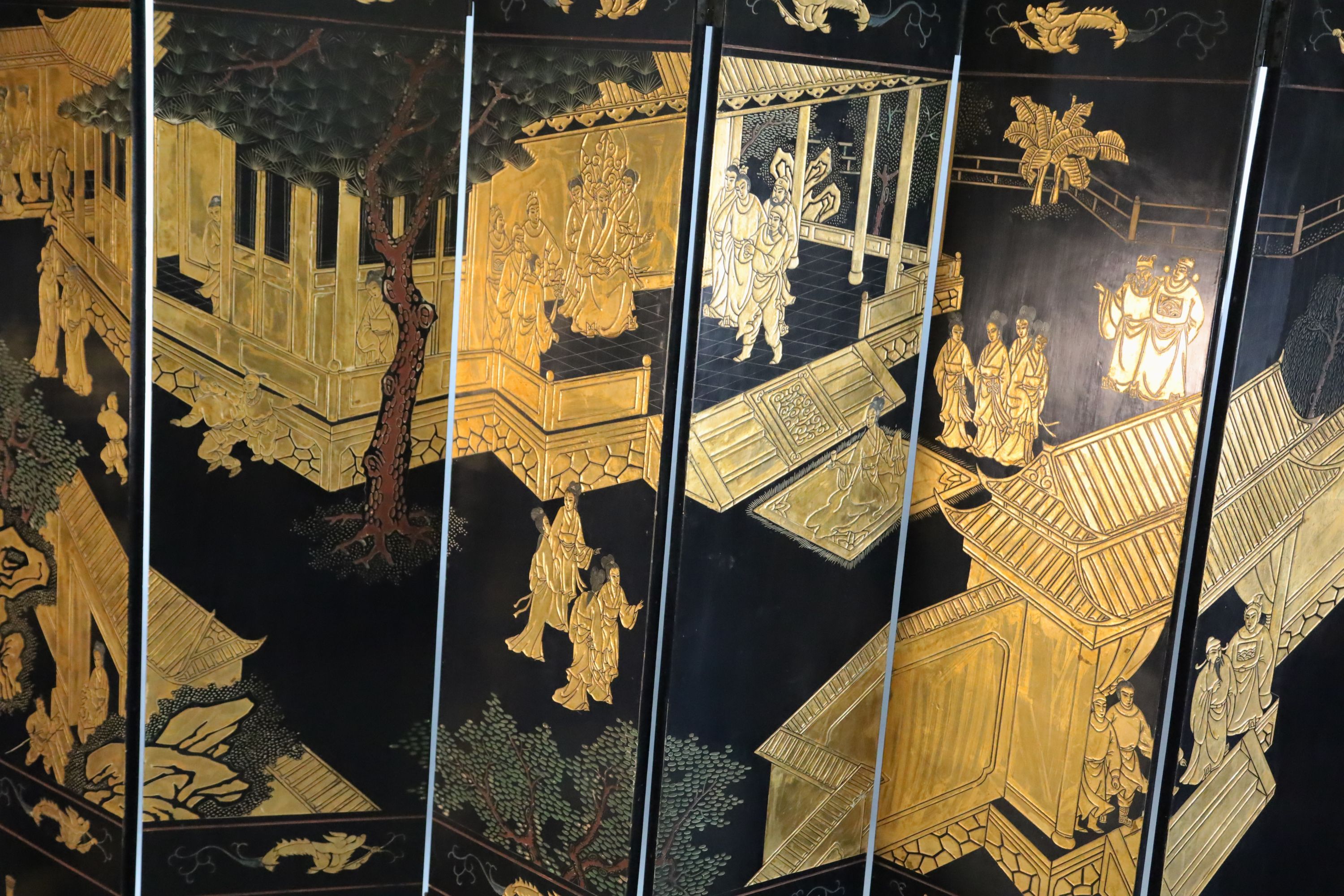 A late 19th century Chinese Coromandel lacquer eight fold dressing screen, each panel W.1ft 4in. H.6ft 9in.